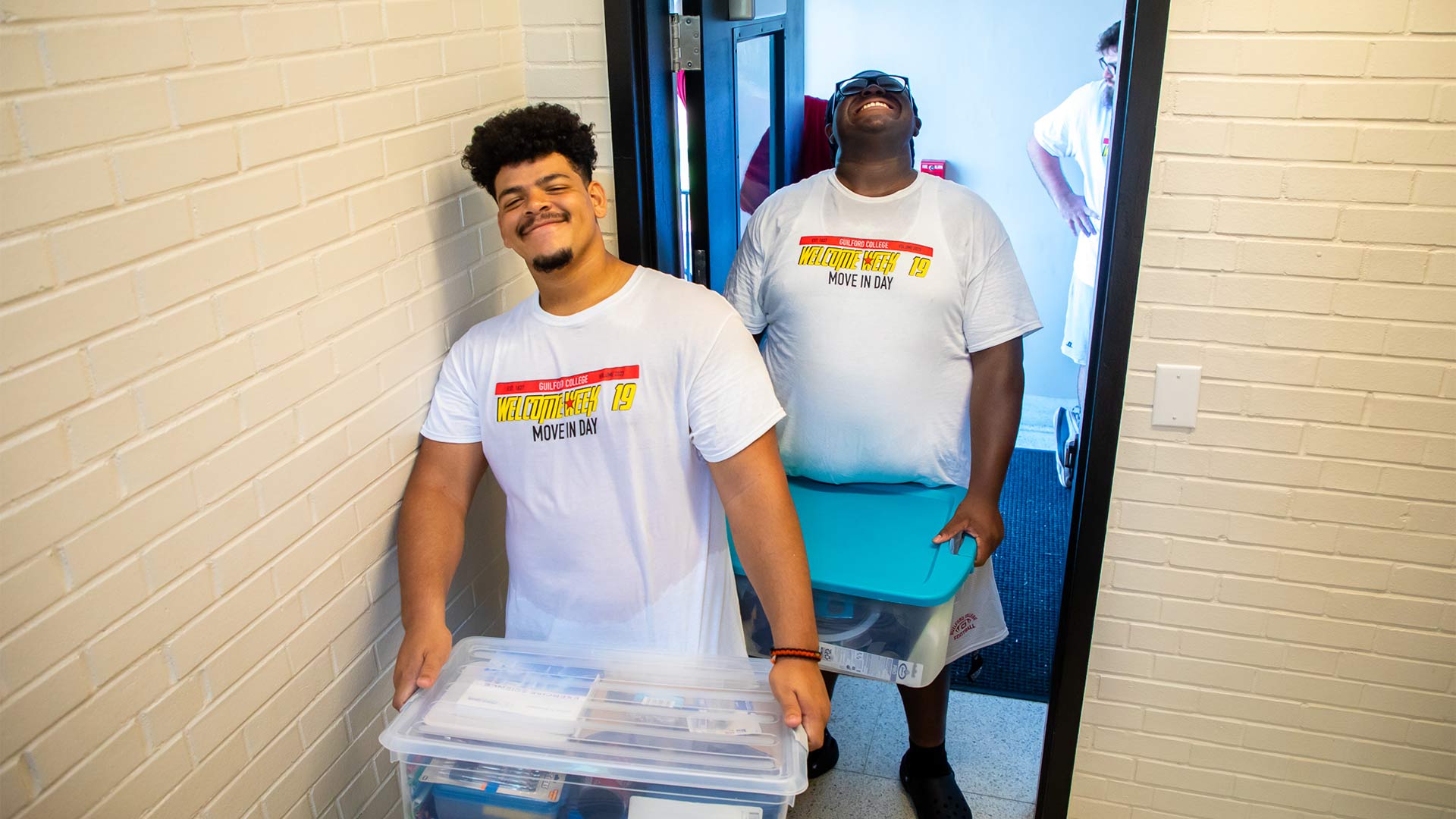 Members of Guilford's football team help new students move in to their residence halls.