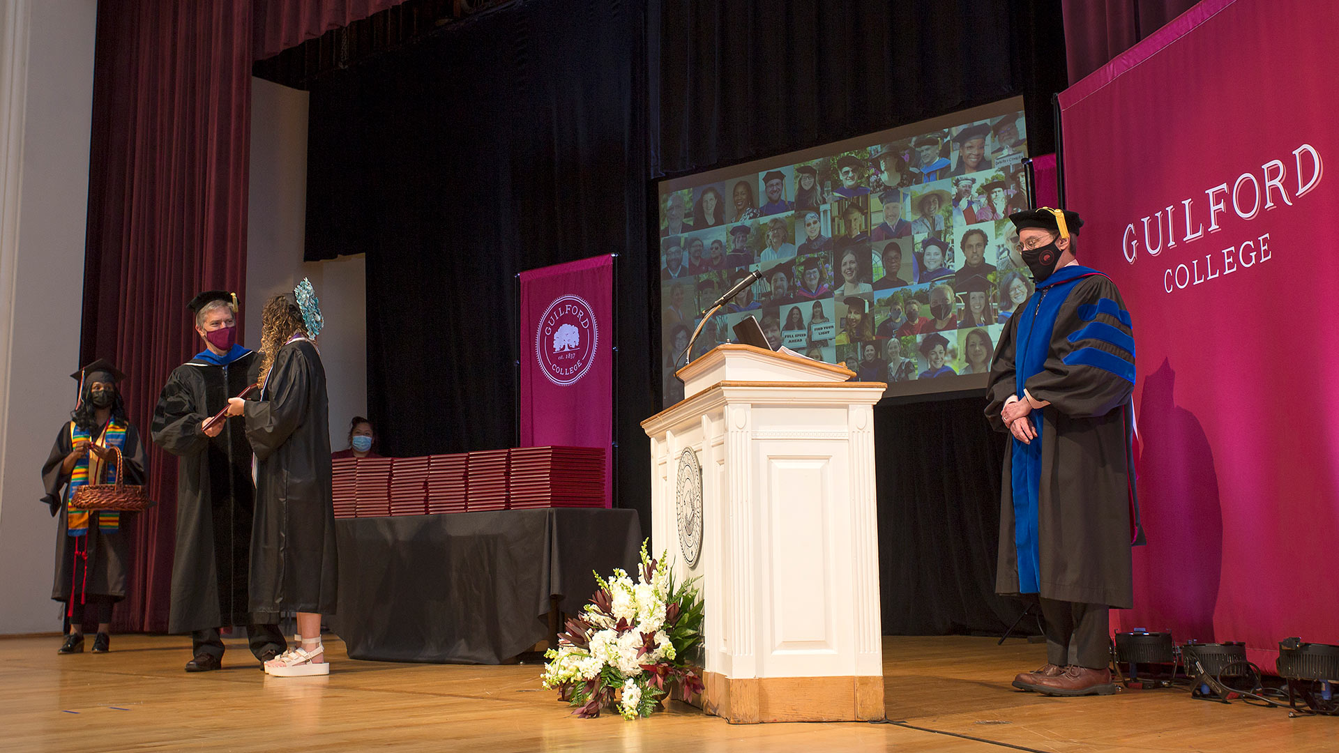 Faculty and staff stand on stage in Dana Auditorium.