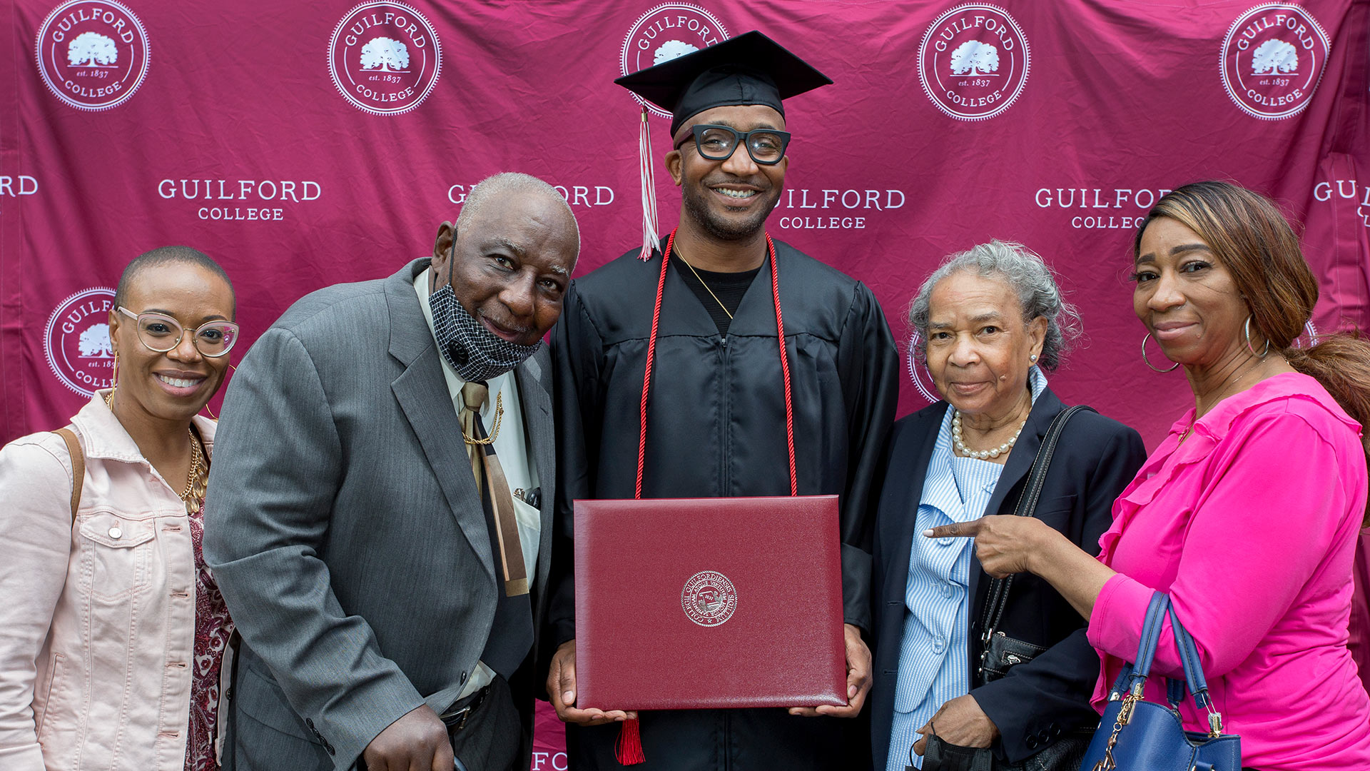 A student is surrounded by family members at Commencement.