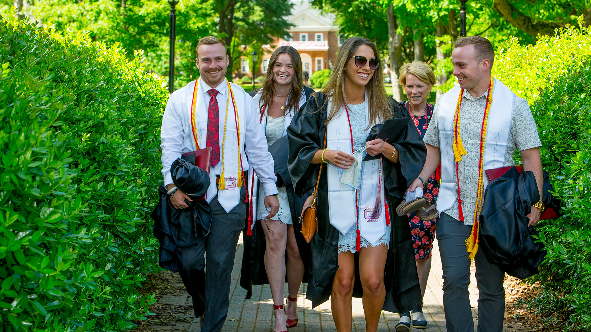 Graduating student athletes walk together across the Quad.