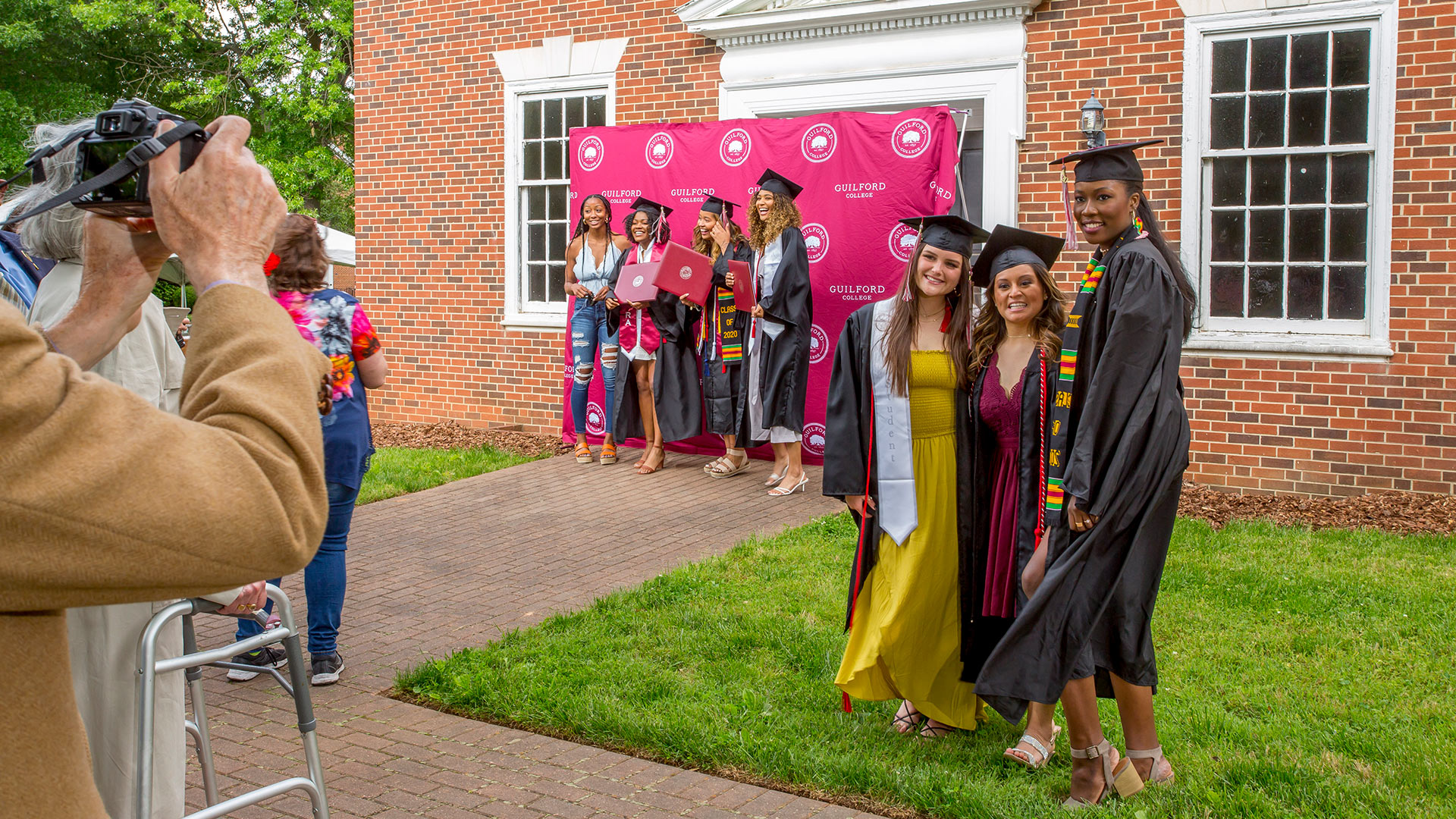 Two groups of students take photos outside the auditorium.