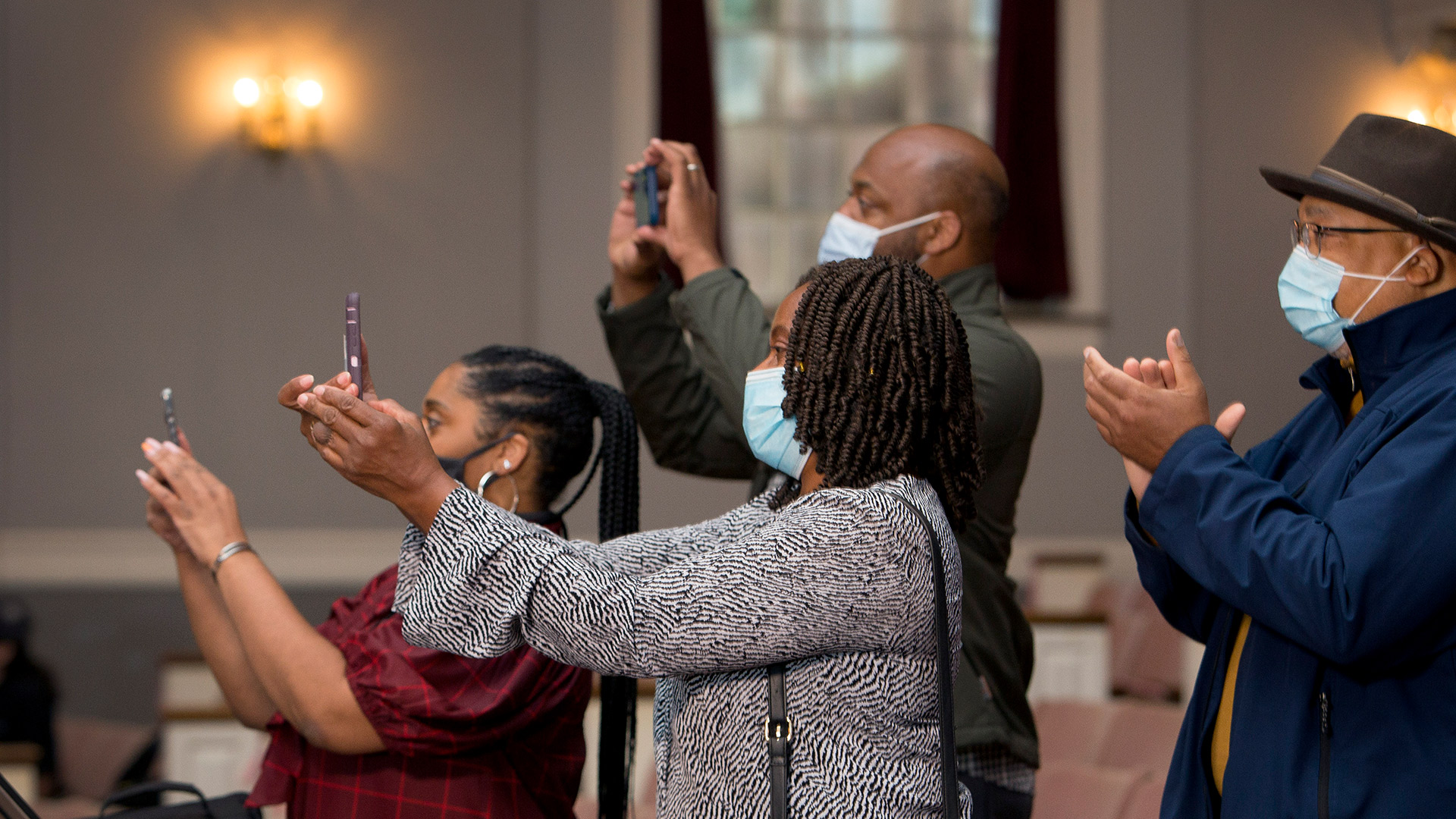 Several family members take photos with their phones in the family viewing area.