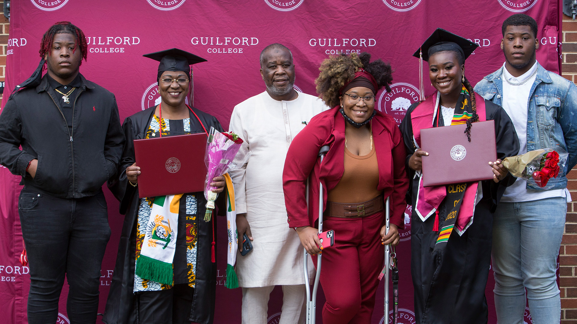 Graduates take a photo with friends outside Dana Auditorium.