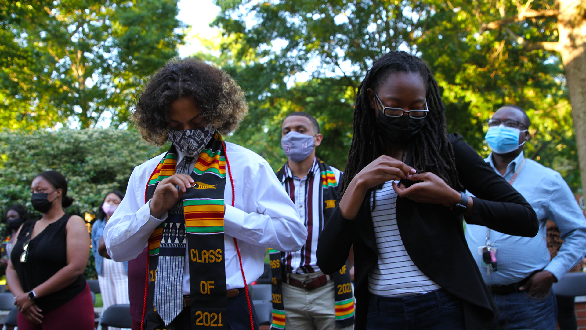 Graduates put on their pins at their Sankofa celebration on May 6, 2021.