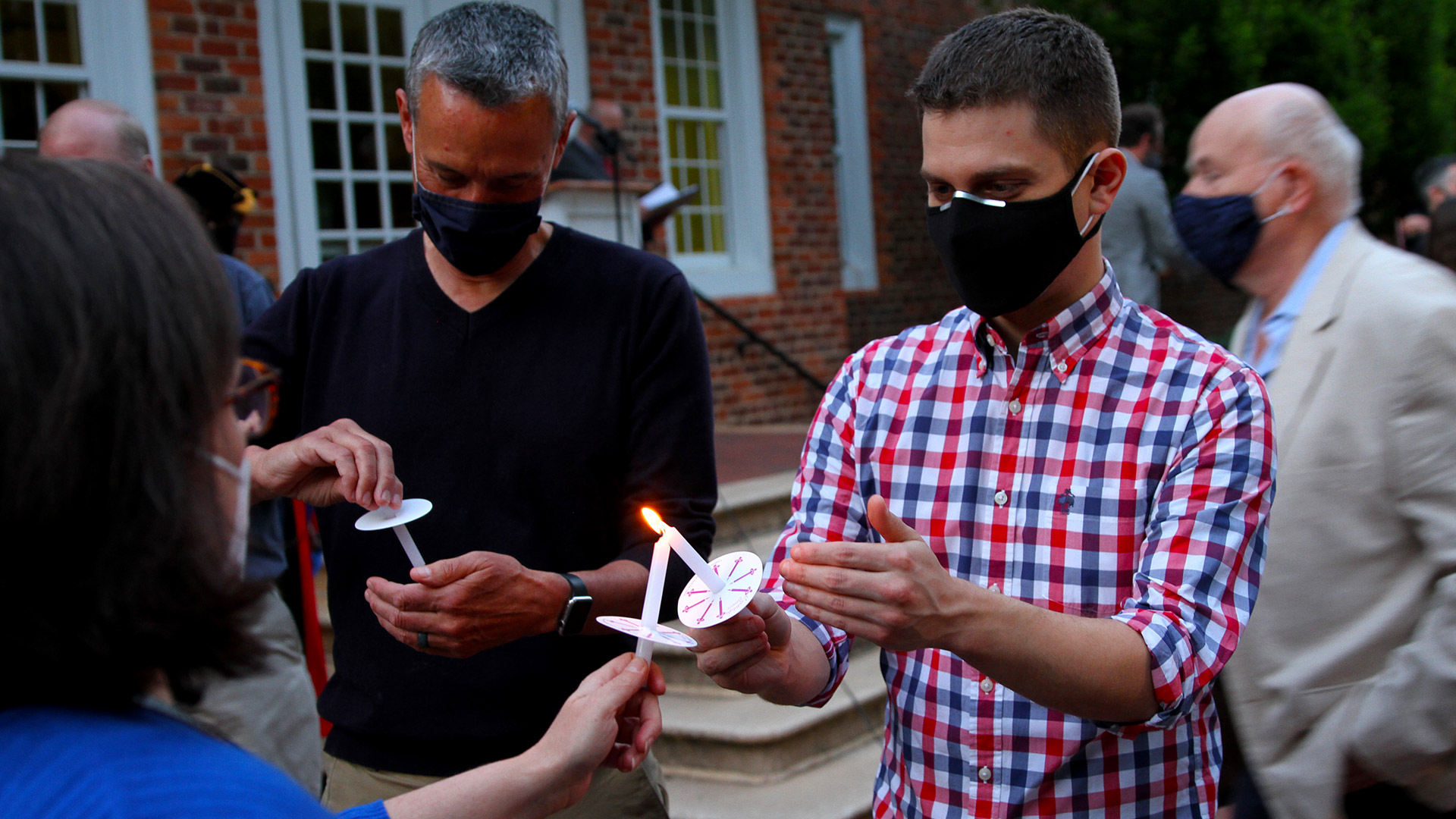 Graduates share flames from their candles with their professors, advisers, and families at Toast to the Light 2021.