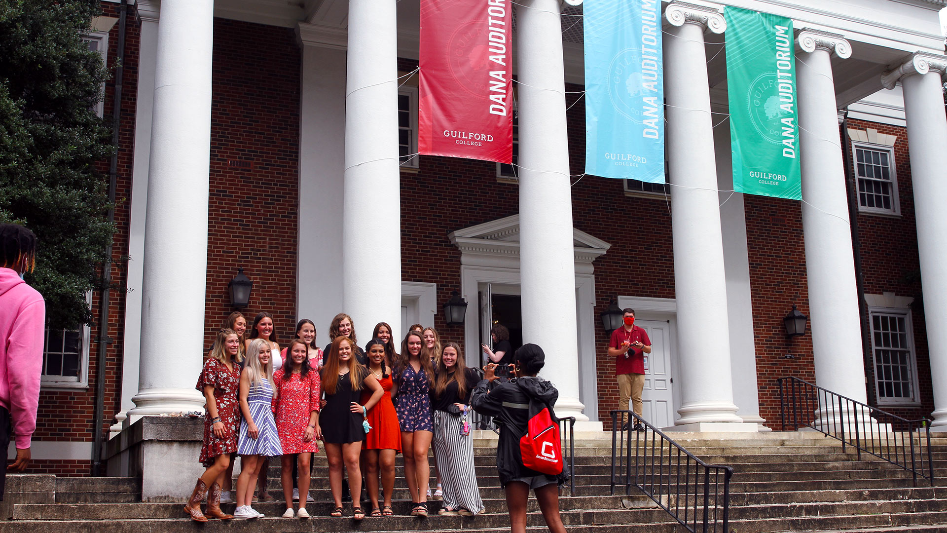 A group of about 12 students takes a group photo on the steps of Dana Auditorium after Convocation.