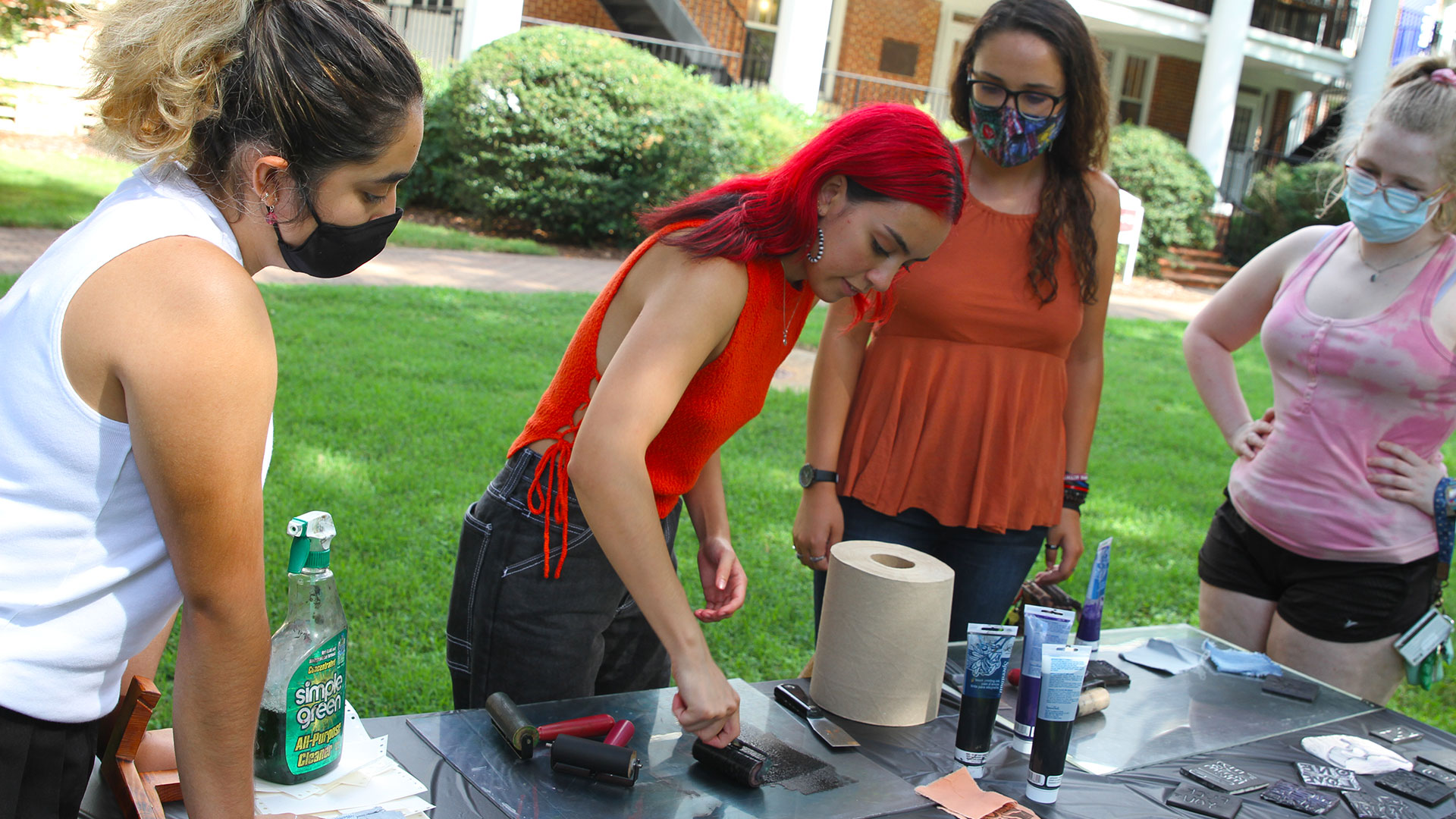 Students take turns using templates to make decals at Free Press on the Quad.