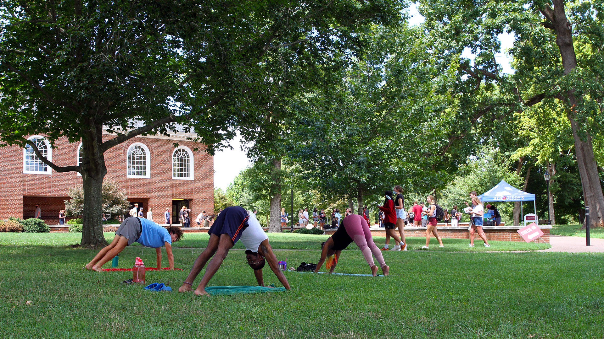 Three students practice their downward dog pose during Yoga on the Quad.