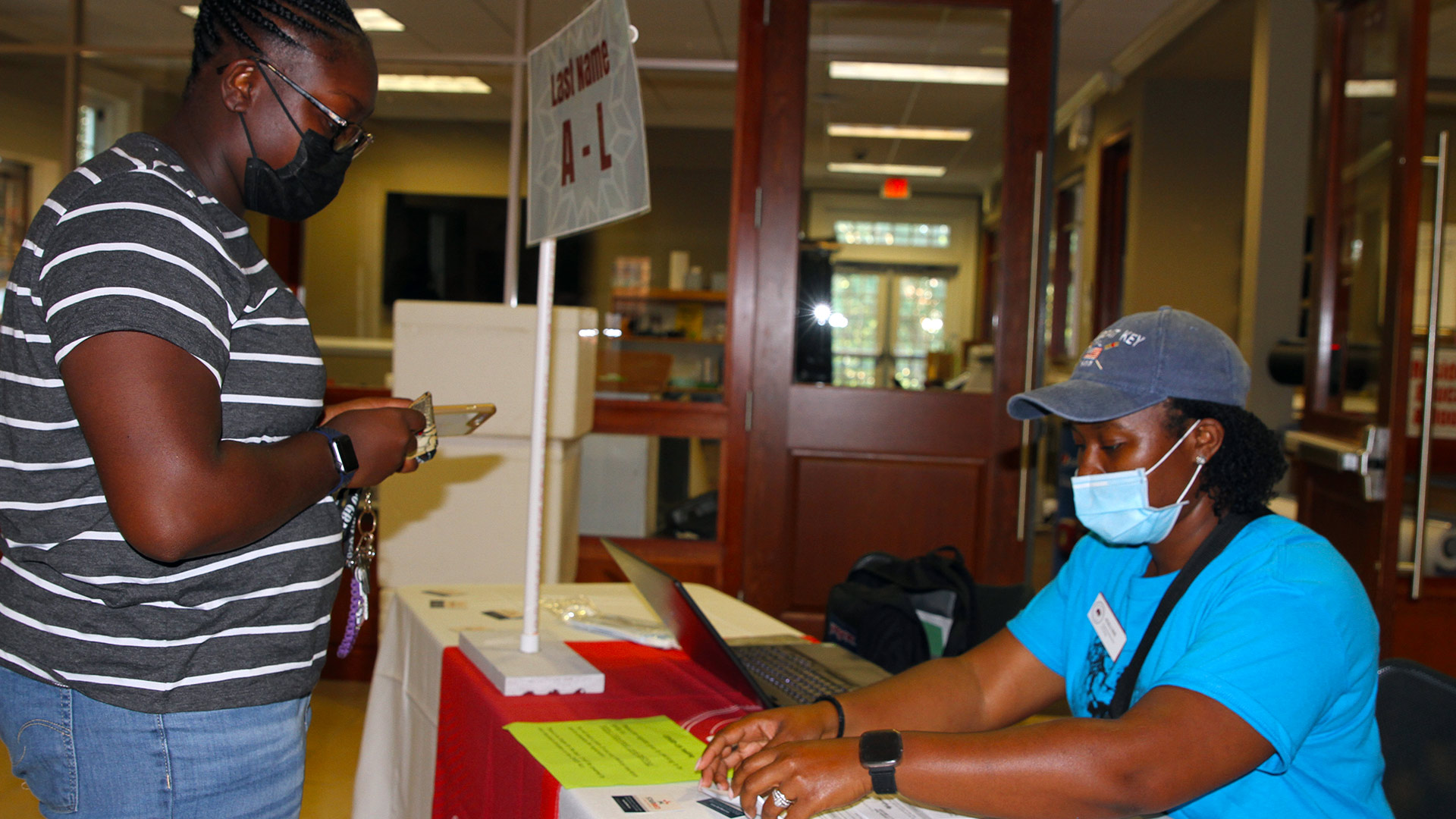 A student checks in a the Housing table in Founders Hall.