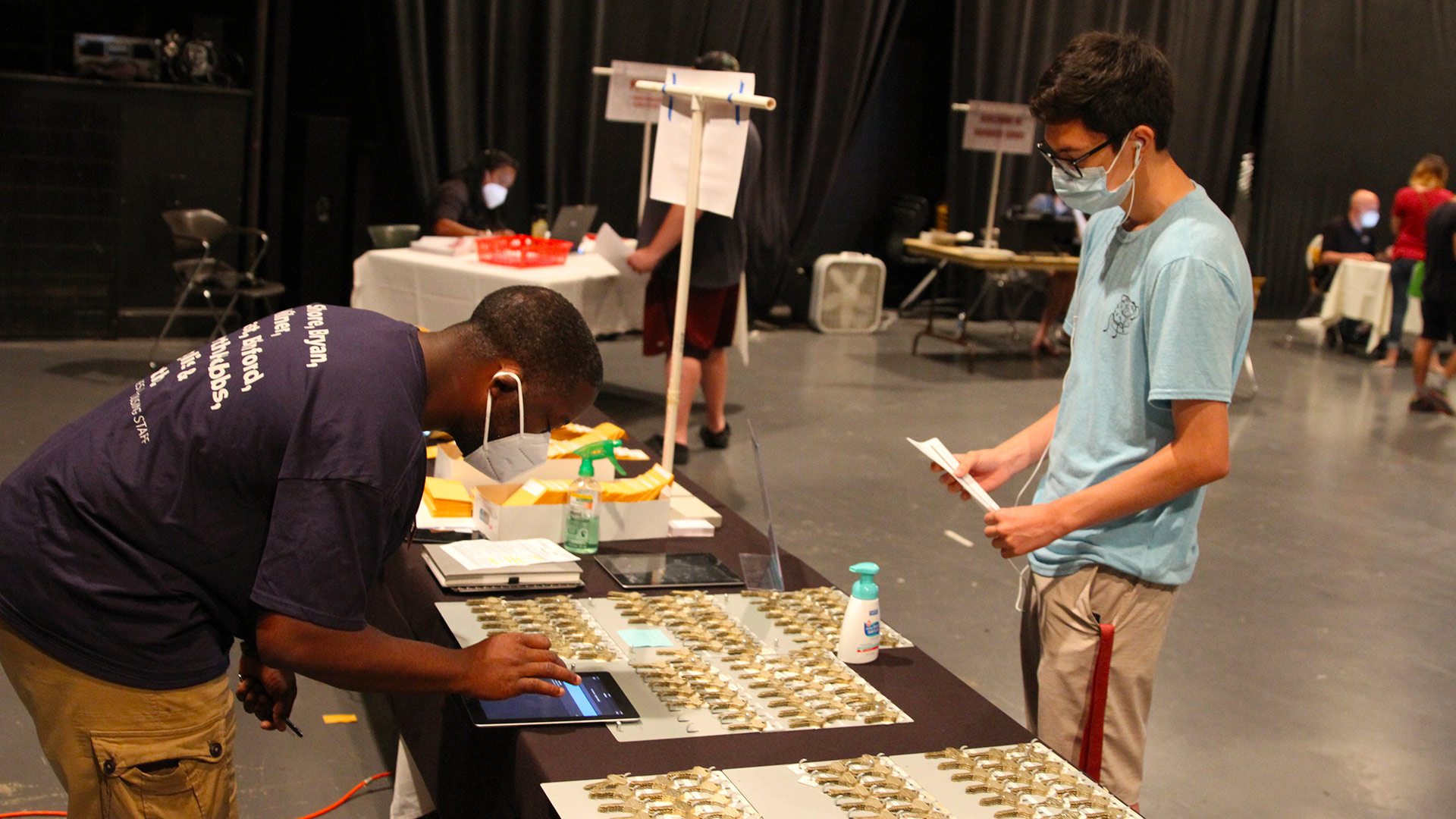 A staff member helps a student find their room key.