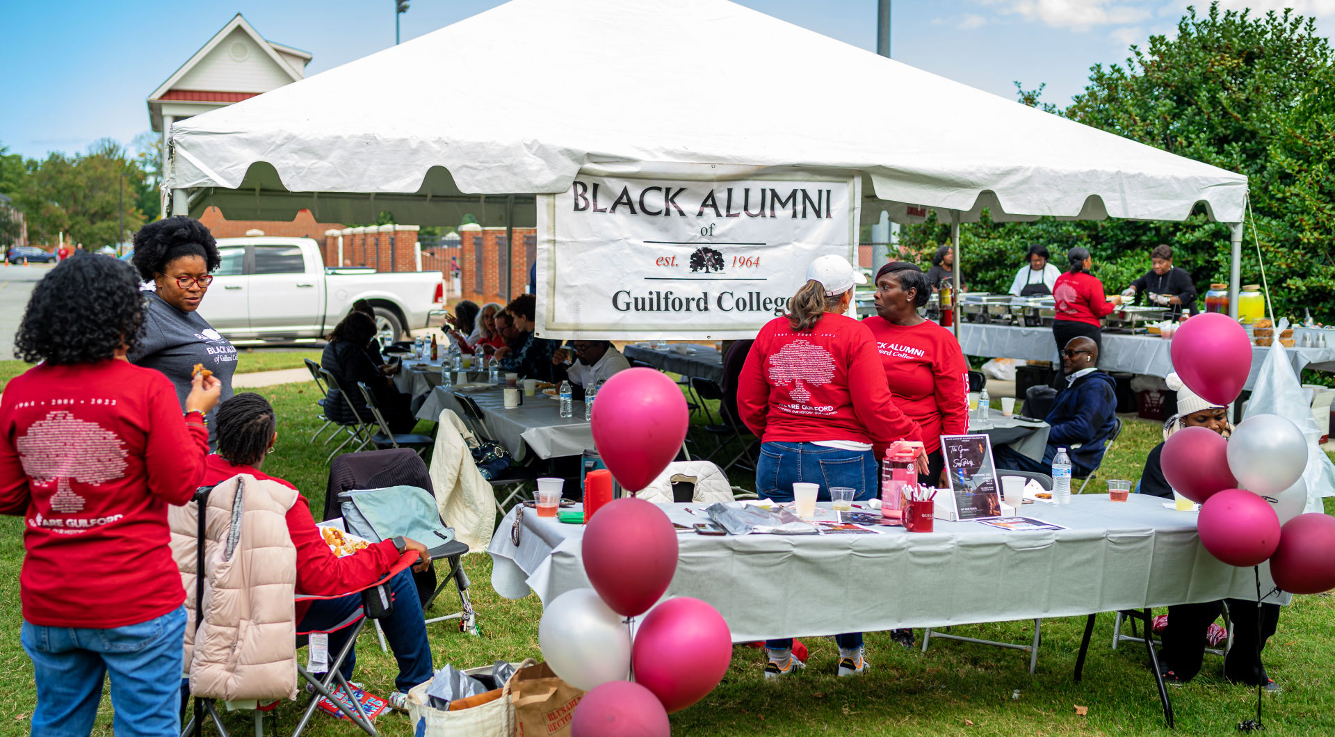 Black alumni of Guilford gather around the BAGC booth at Homecoming.