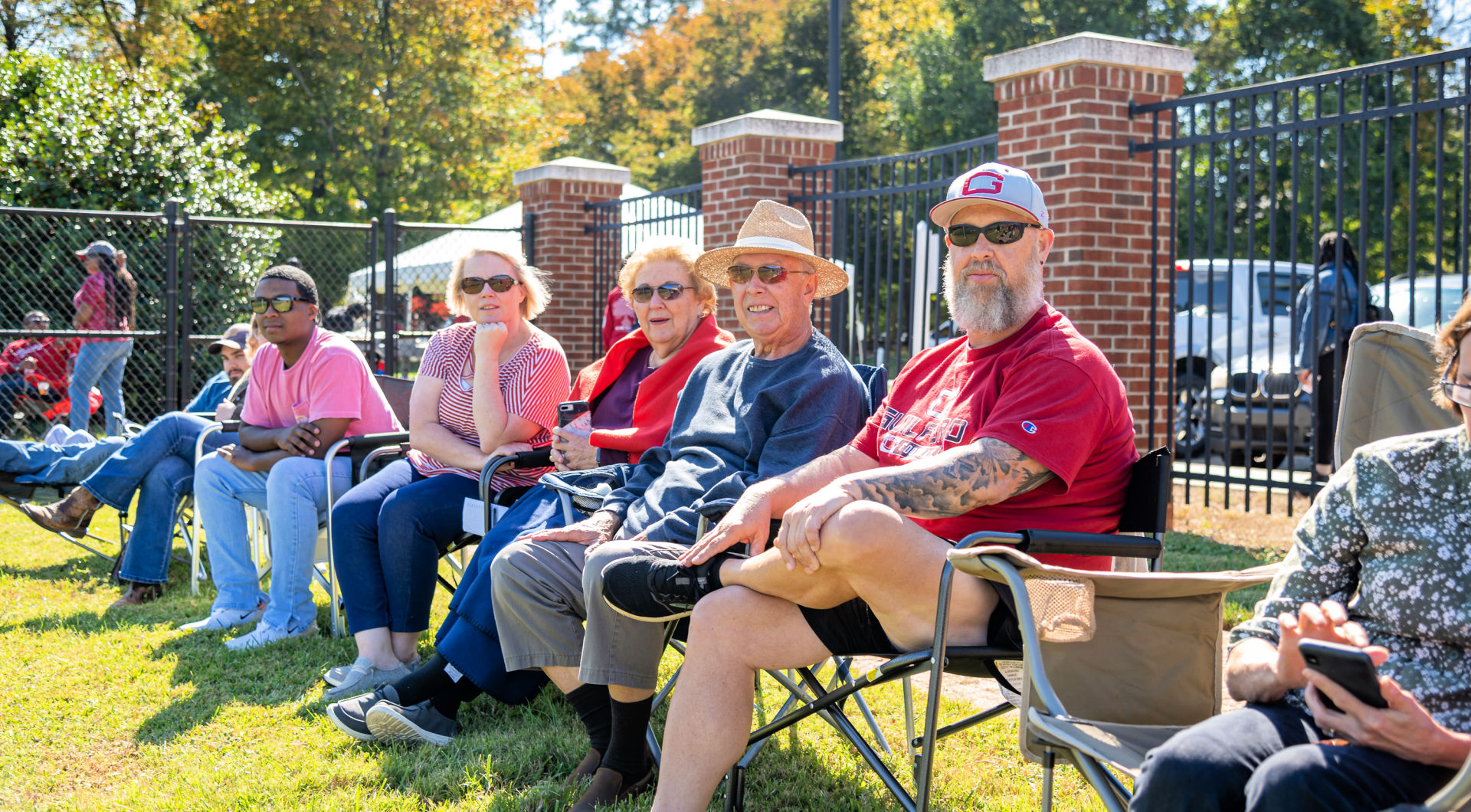 A row of Guilfordians watches the football game from their folding chairs.