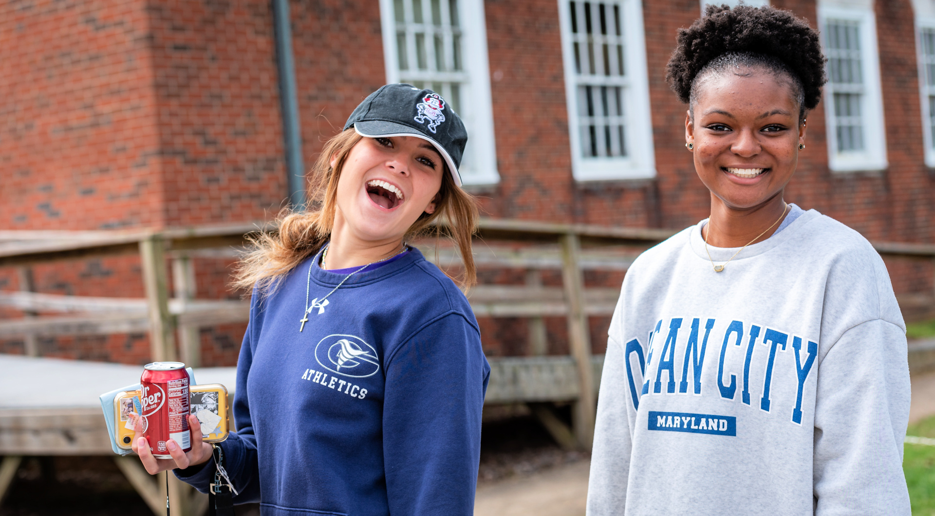 Two Guilford students smile at the camera as they walk to the football stadium.