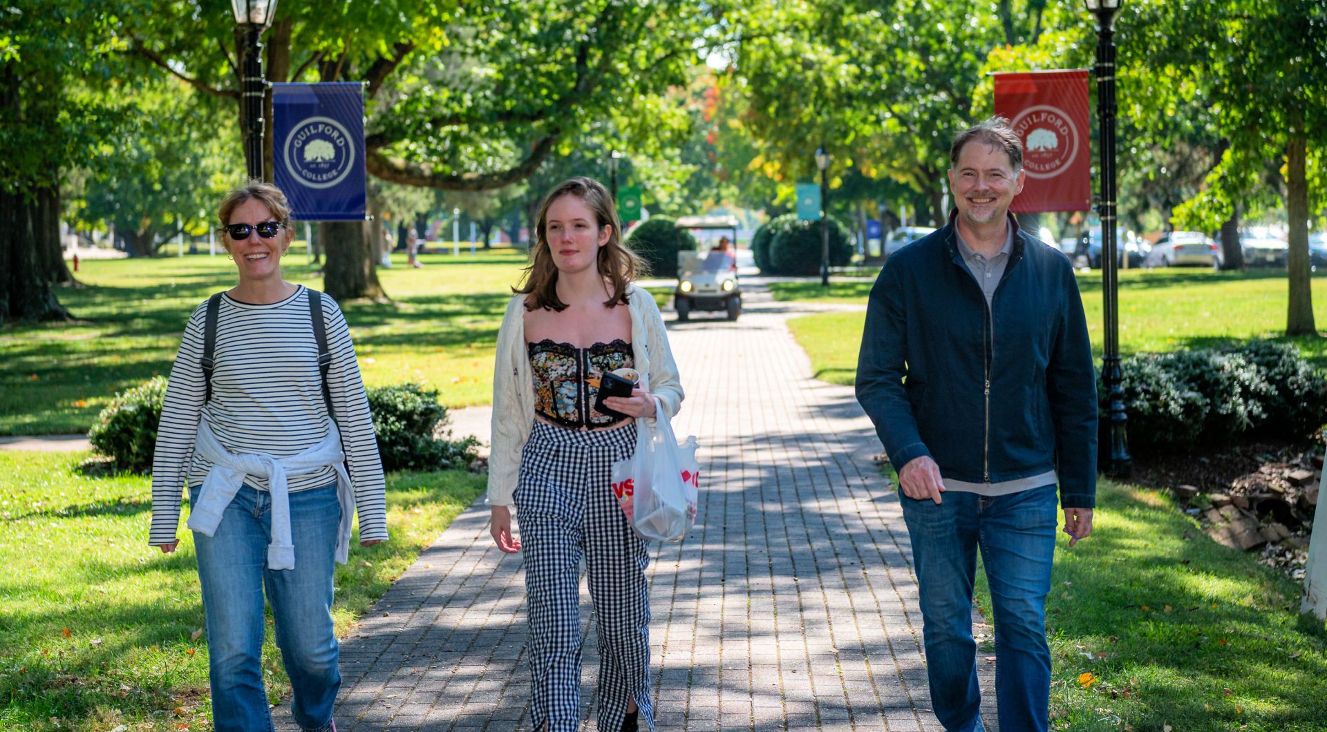 Three Guilfordians walks across the Quad.