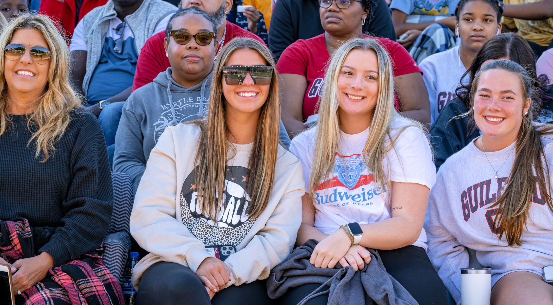 Guilford students smile from the stands during the football game.