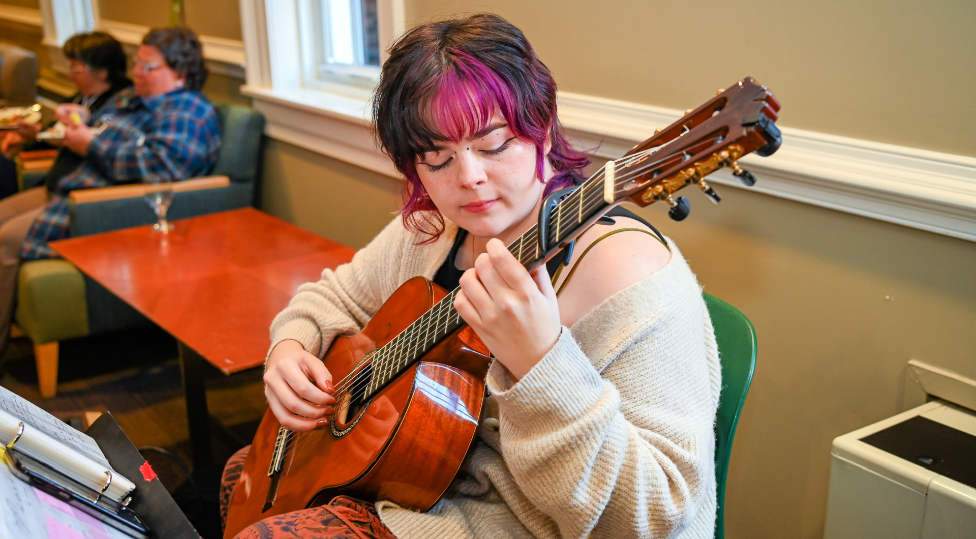 A student musician plays the guitar in Founders Hall.