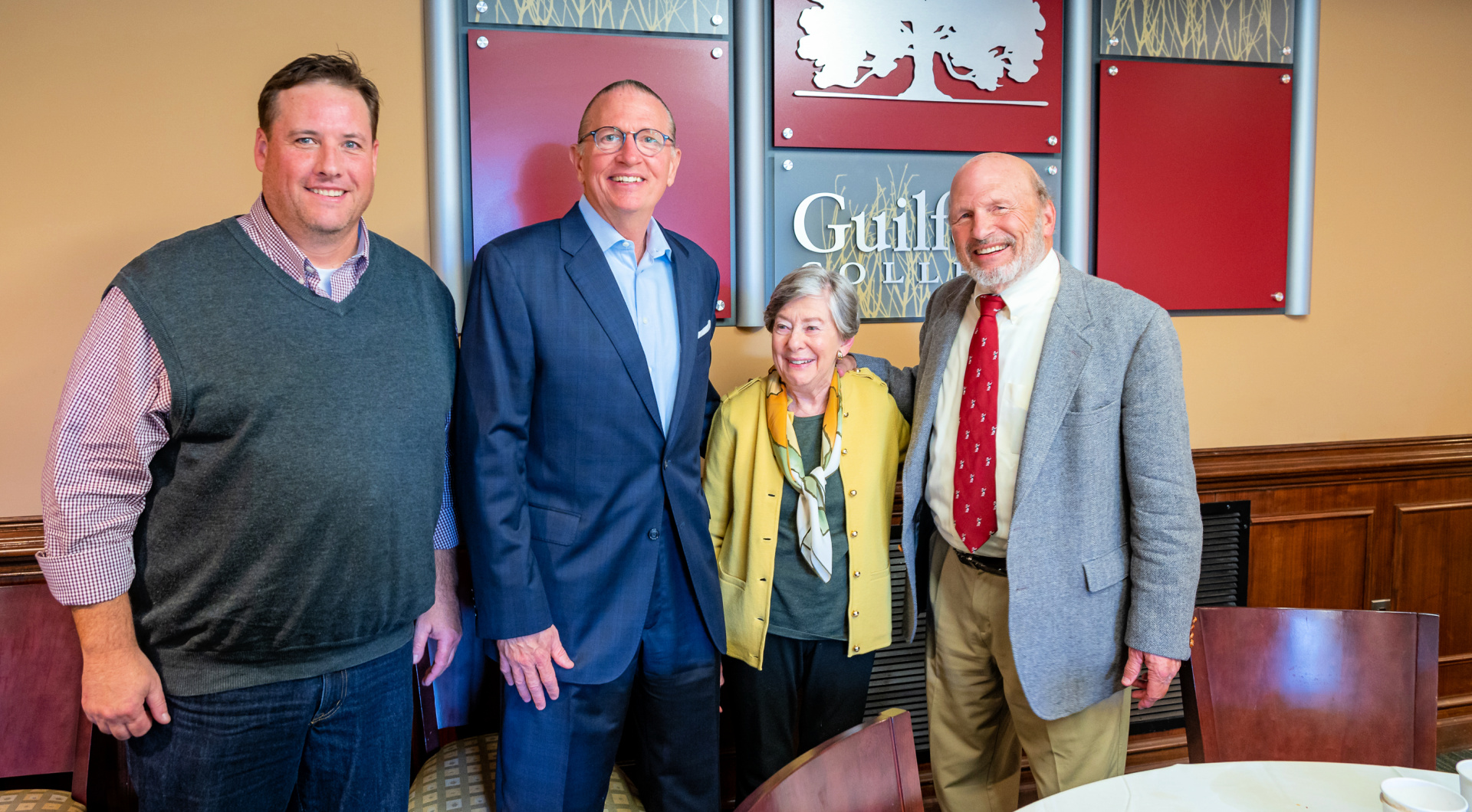 Four Guilfordians smile for a photo in the Gilmer Room.