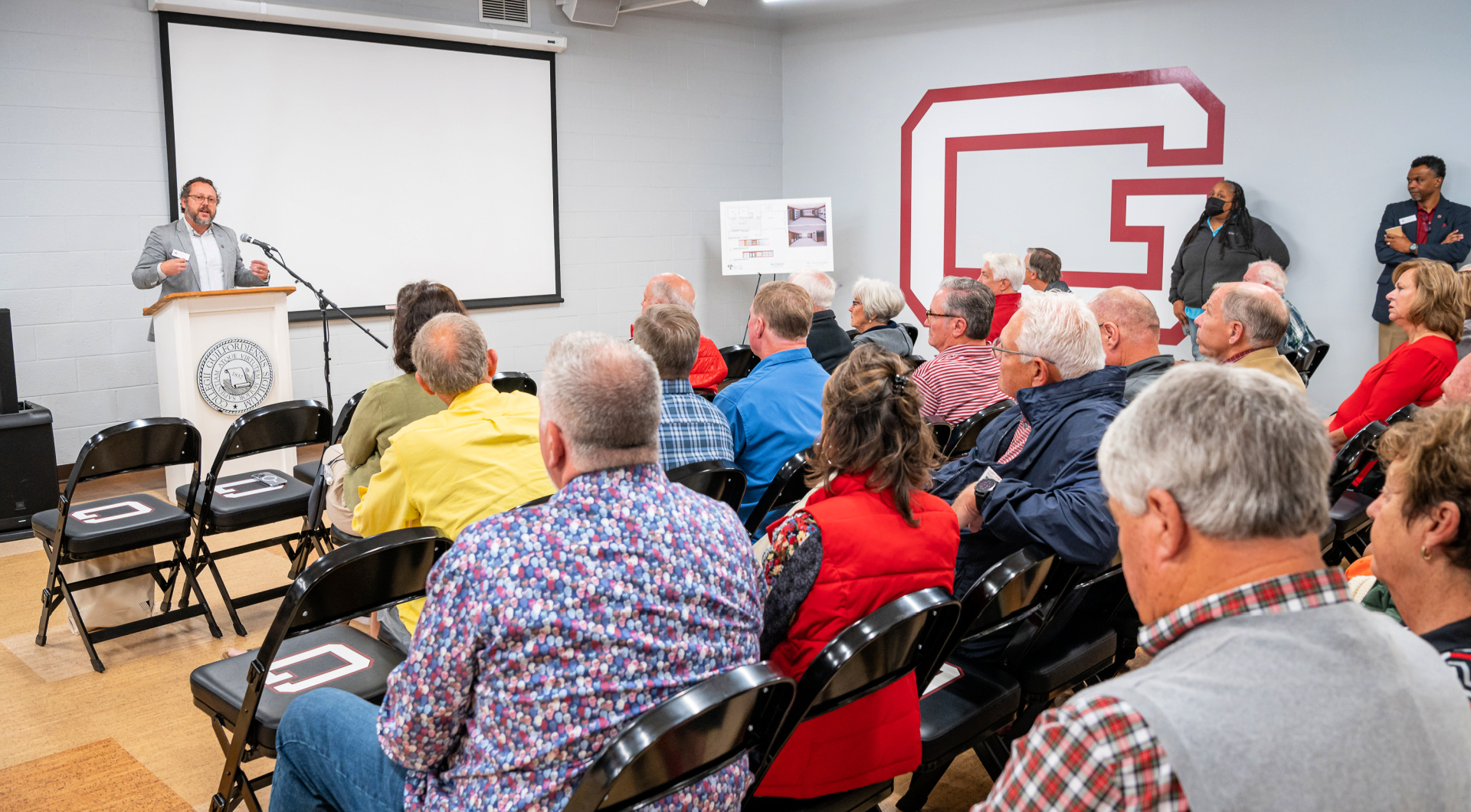 William R. Rogers Director of Friends Center Wess Daniels speaks to Guilfordians from a podium in Alumni Hall.