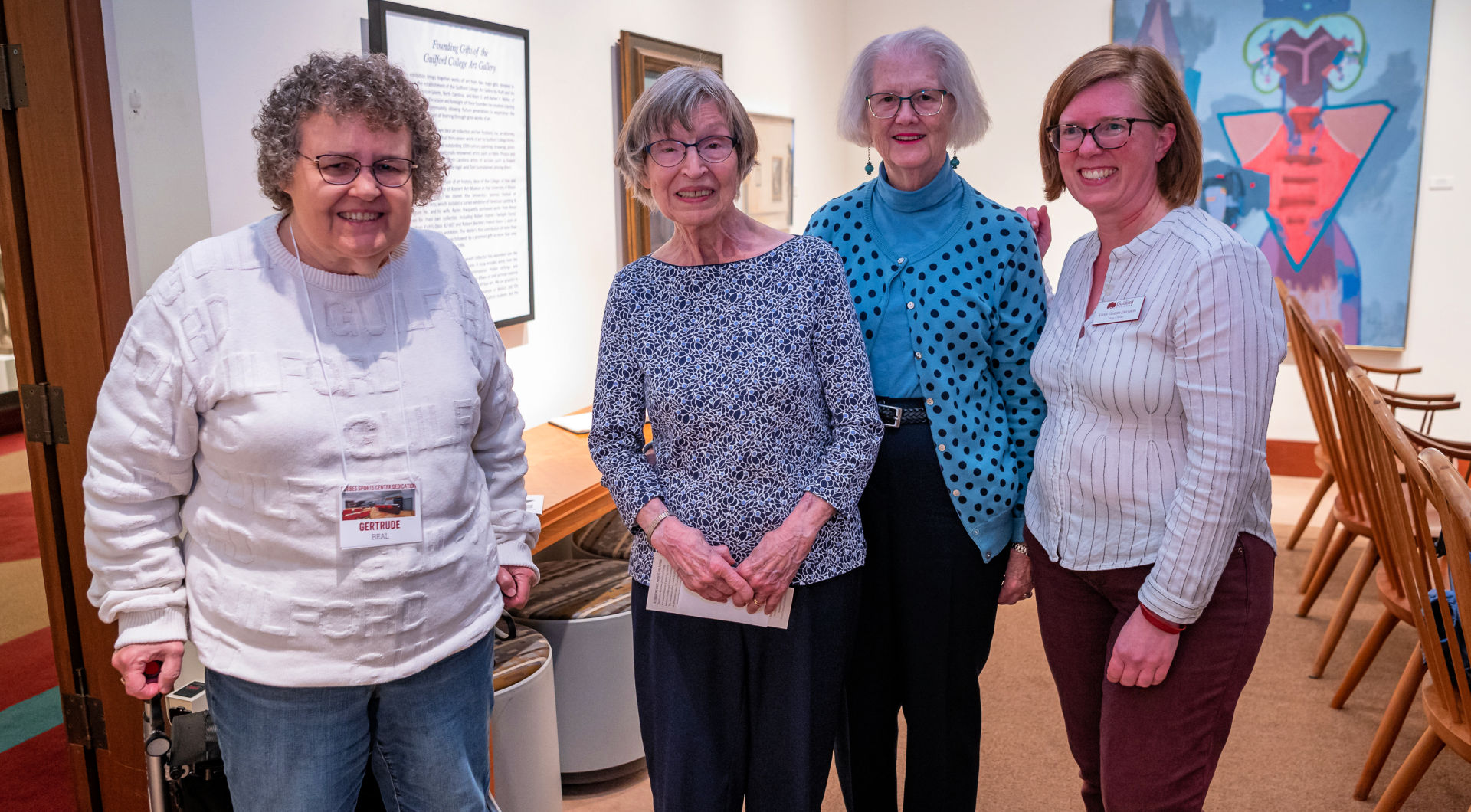 Three Guilfordians pose for a photo with College Archivist and Librarian Gwen Gosney Erickson (far right).