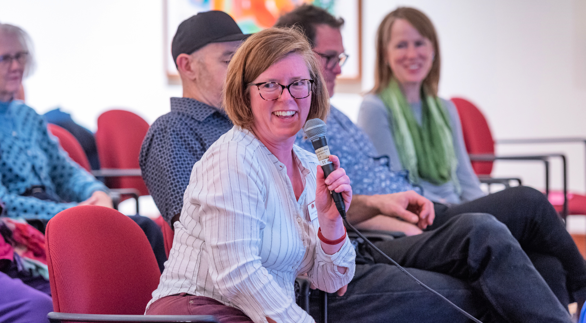 College Archivist and Librarian Gwen Gosney Erickson smiles as she speaks into the microphone in the Art Gallery.