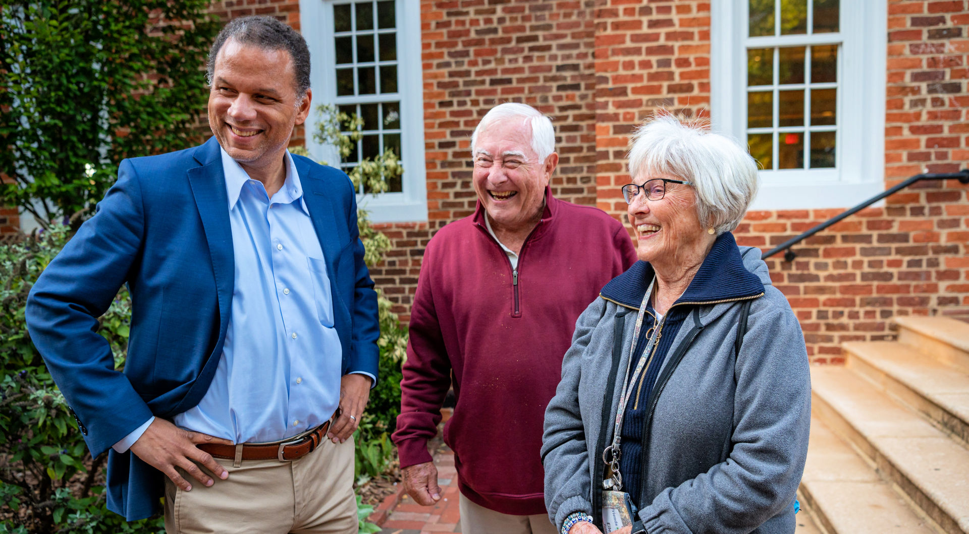 President Kyle Farmbry (left) smiles as he chats with two Guilfordians.