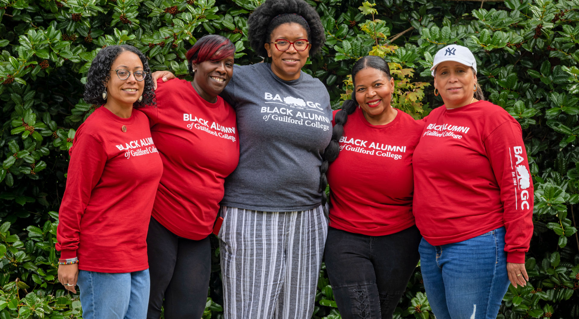 A group of Five Guilfordians wearing Black Alumni t-shirts take a group photo.