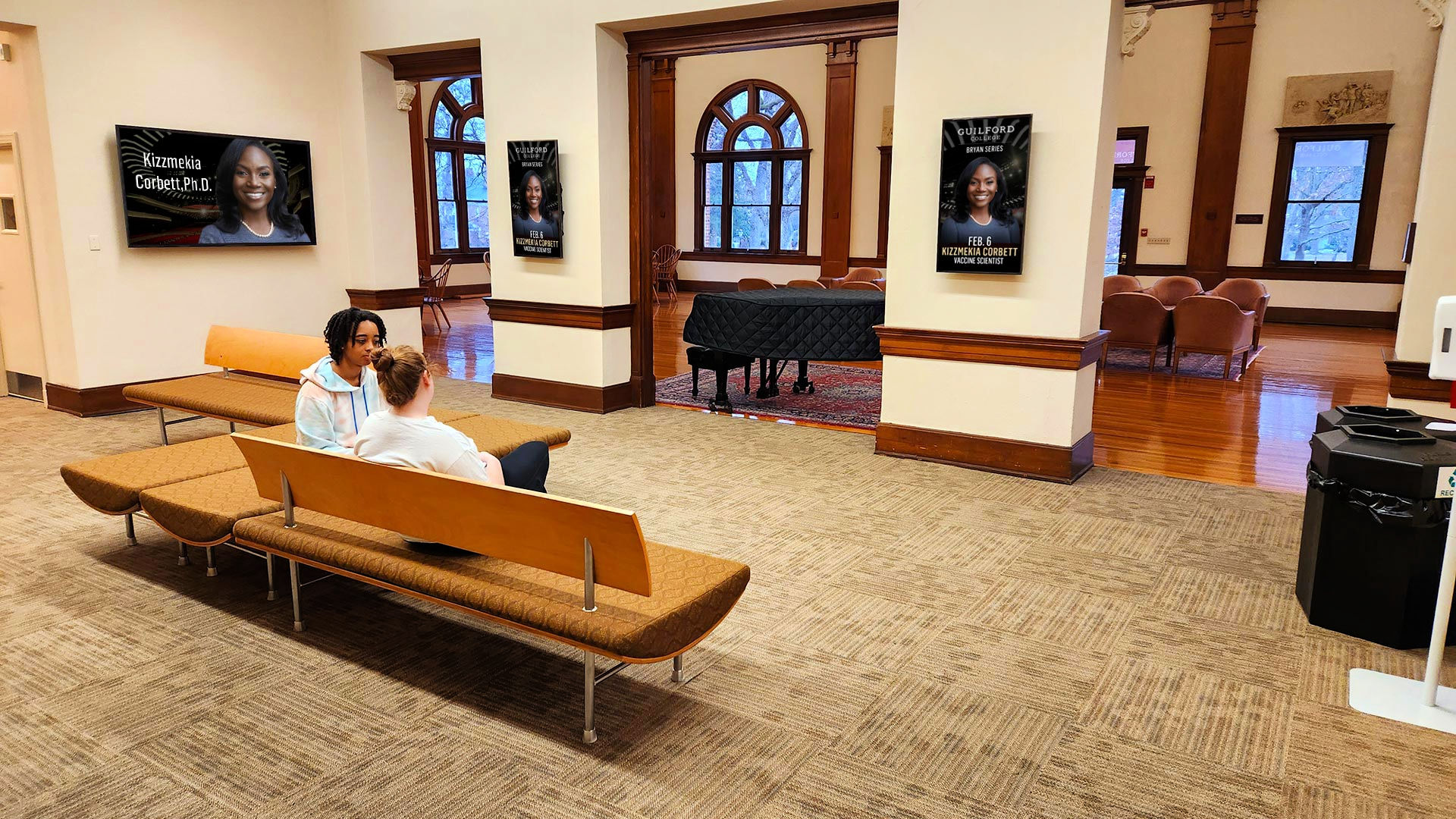 Two students sit and chat on new seating in the updated Carnegie Gallery.