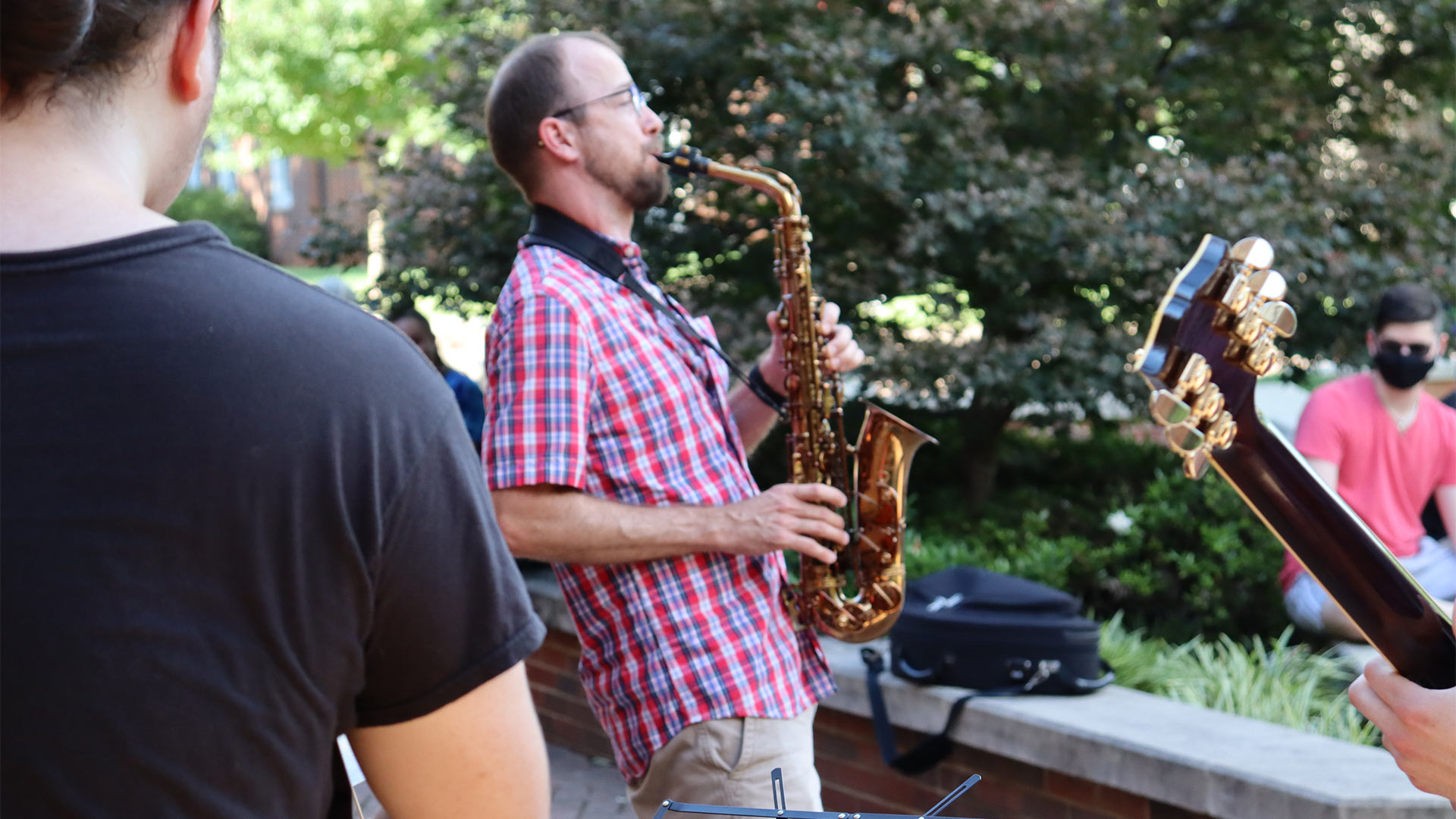 Music Professor Drew Hays plays the saxophone with the student performers.