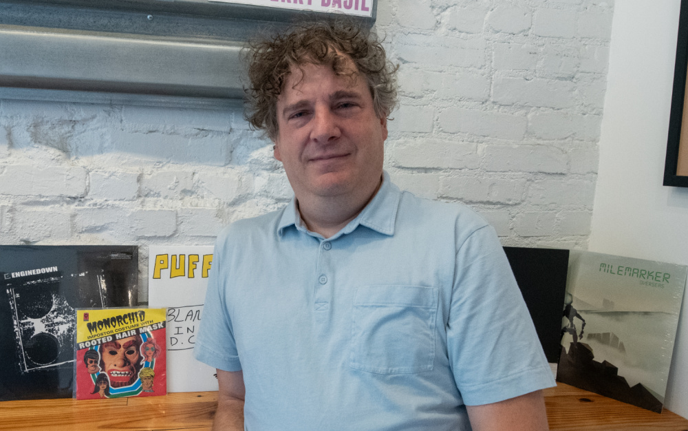 Brian Lowitt standing next to records he produced.