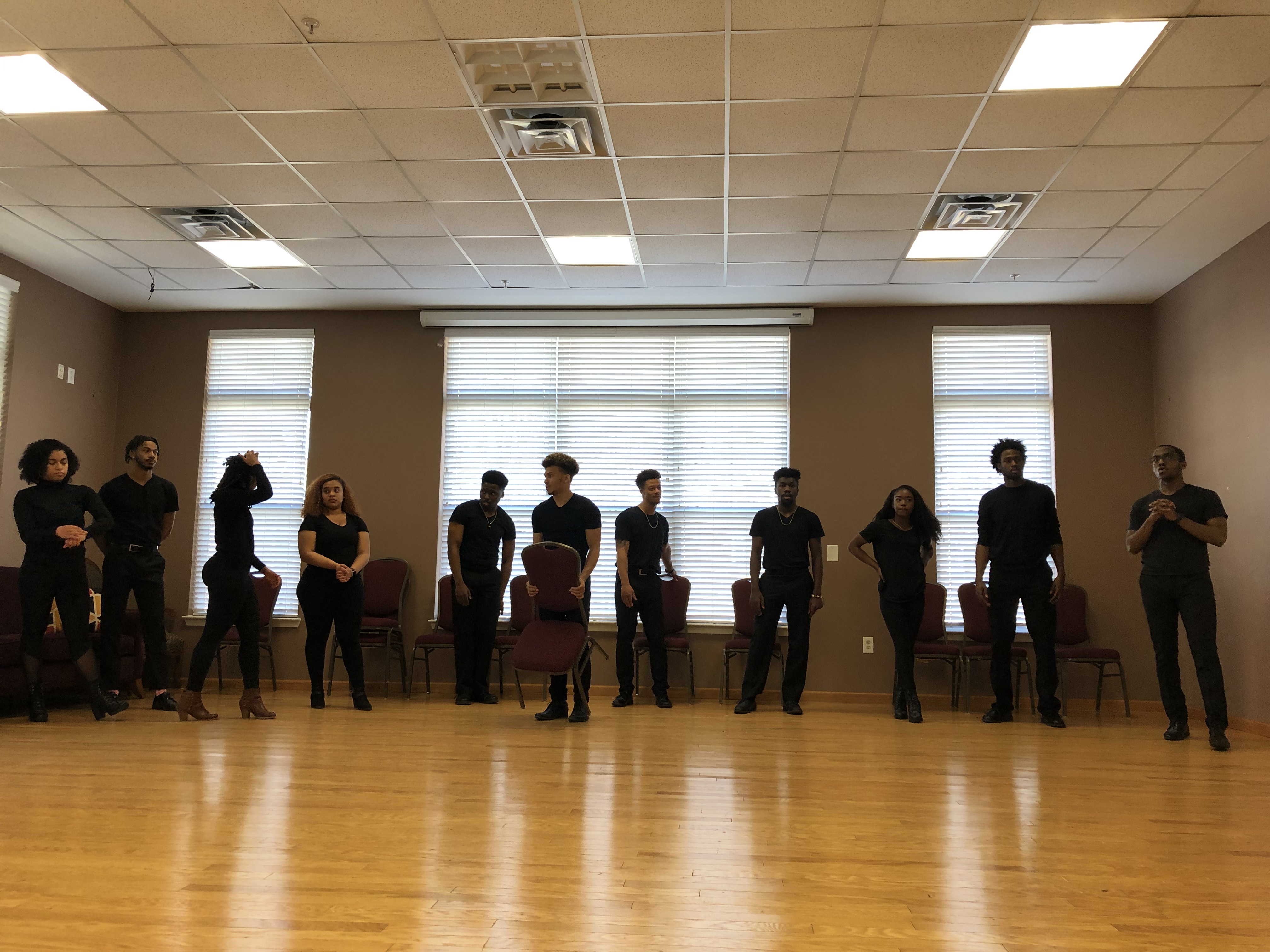 Students line the back of the room, preparing for performance