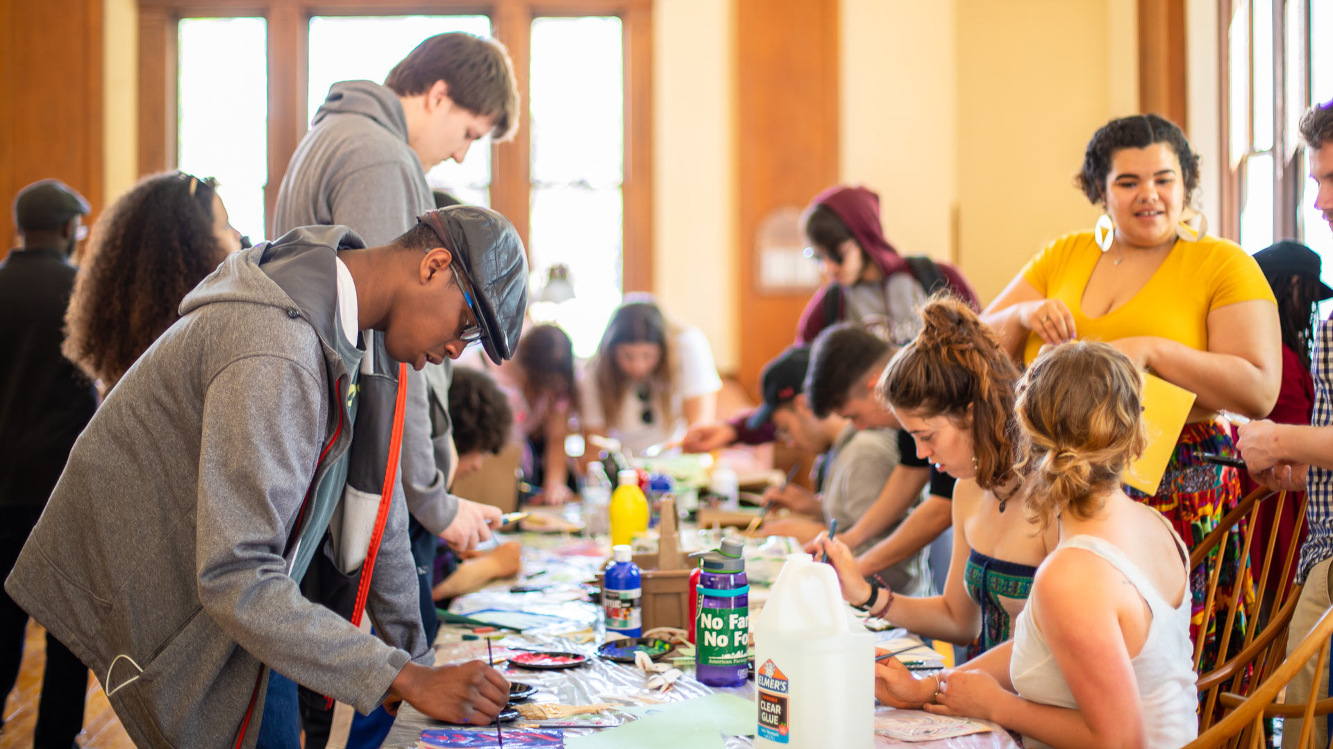 Students offer a hands-on art project to the audience at GUS.