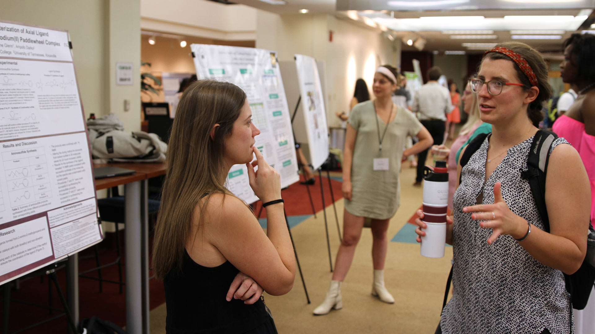 A student gives a poster presentation at GUS.