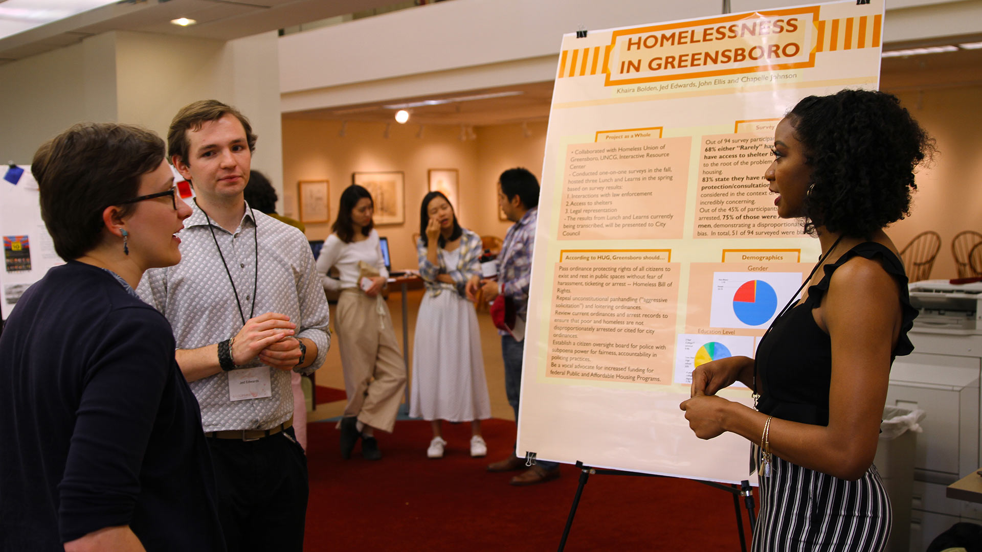 A student gives a poster presentation at GUS.