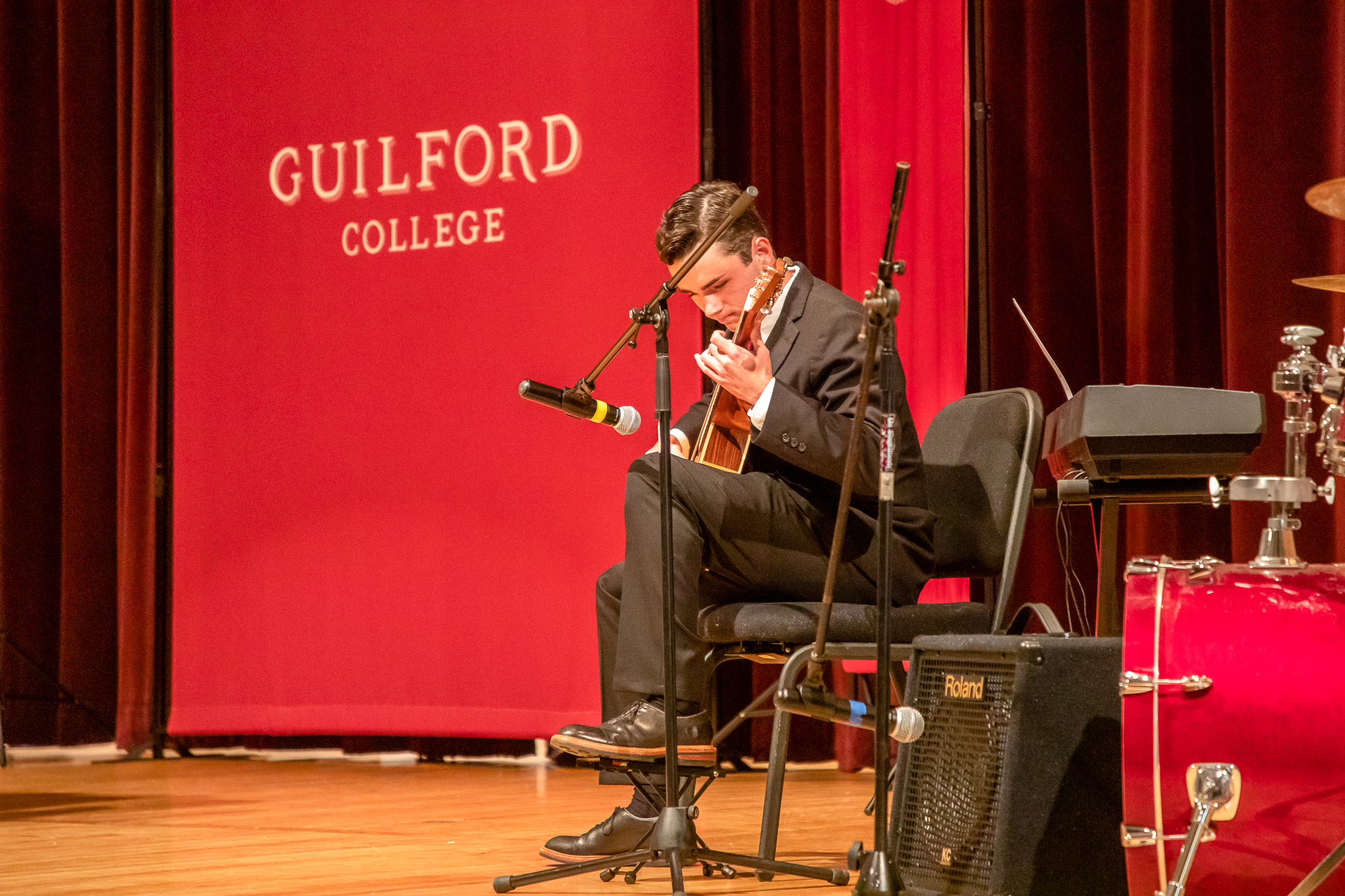 A student musician plays the guitar before Convocation.