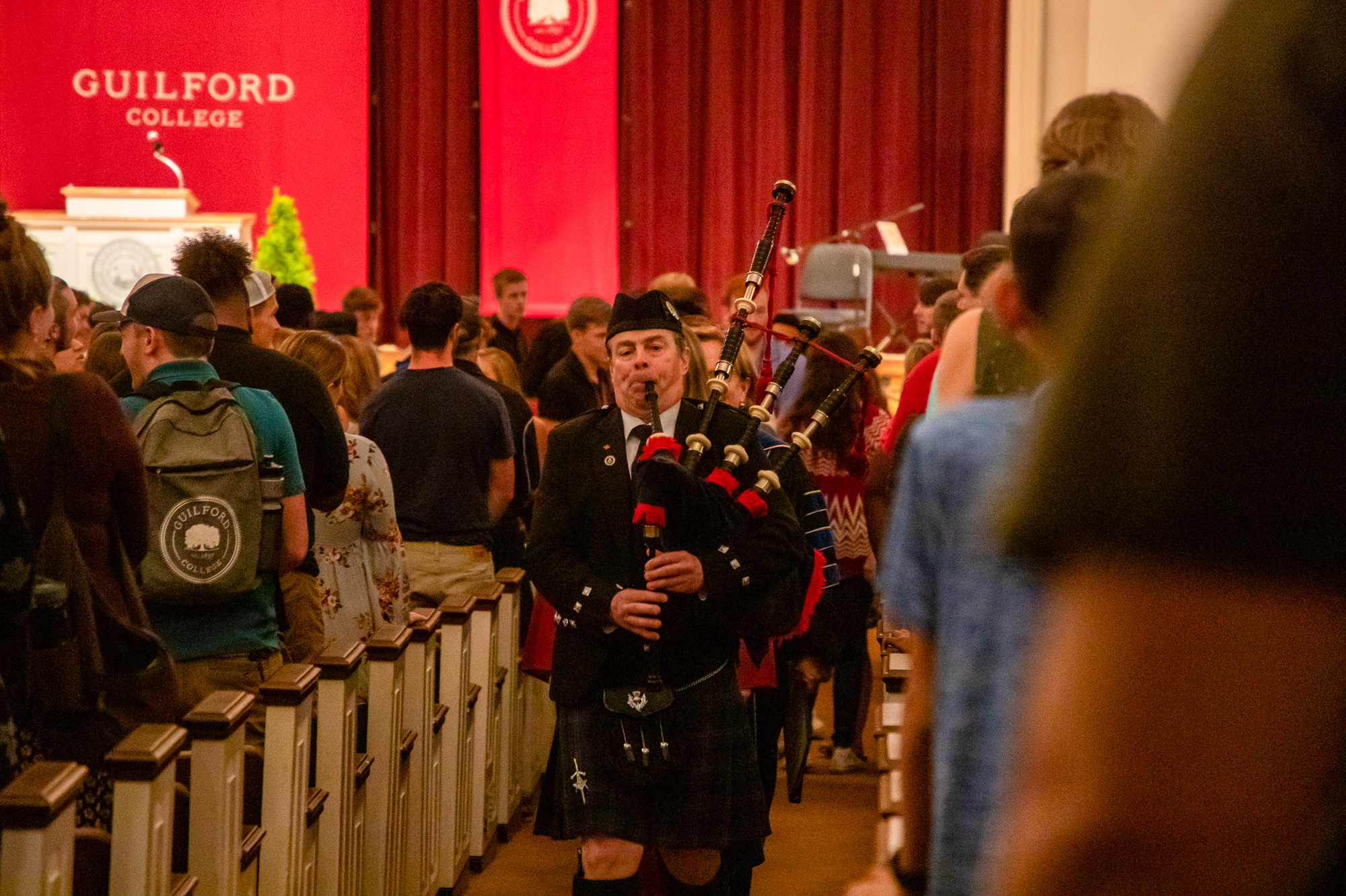 A bagpiper leads the crowd out of Dana Auditorium after Convocation.