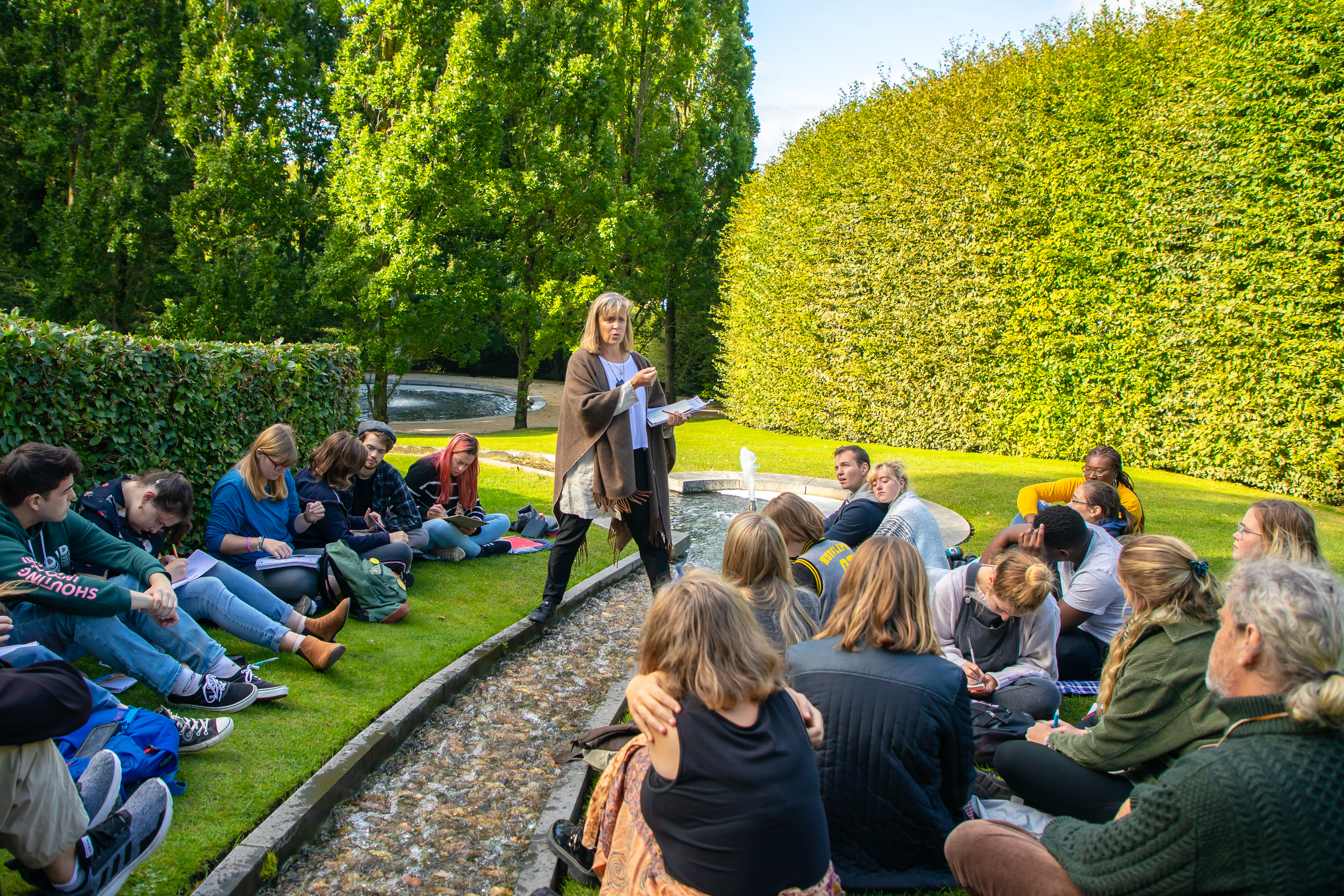 Students listen to Professor Michele Malotky outside Alnwick Castle during a study abroad trip.