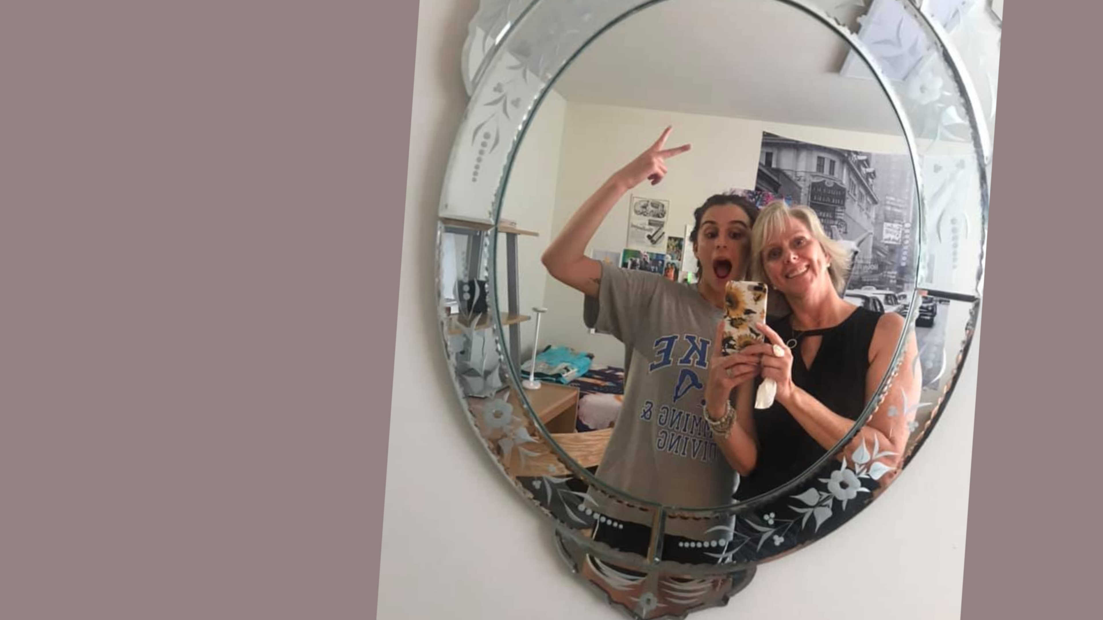 A mom and daughter take a silly mirror selfie during move-in.
