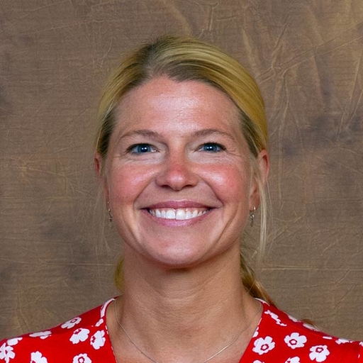 Sarah Munro in a red dress with a white flower print.