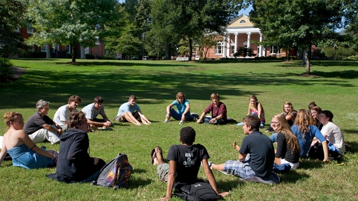 A class sits in a circle on the Quad.